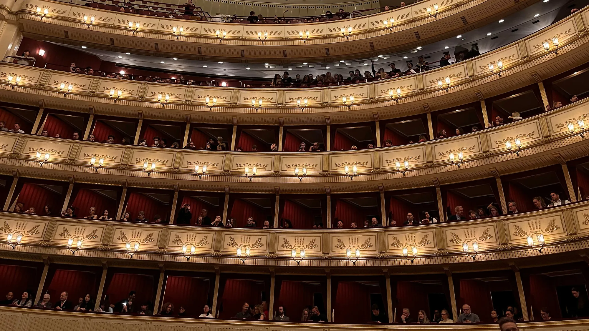 Golden rows of seating with red velvet accents