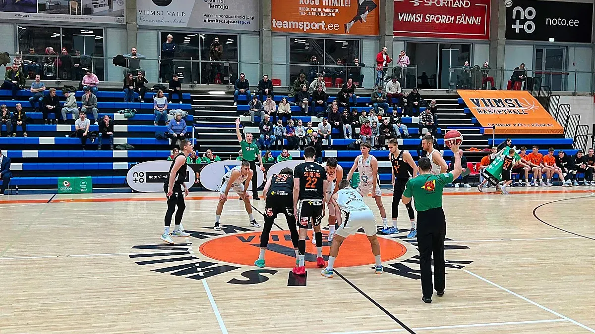 Two adult mens basketball teams on the court for tip-off