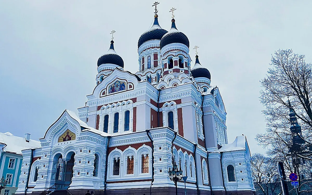 Snow-dusted church with black onion domes and stained glass