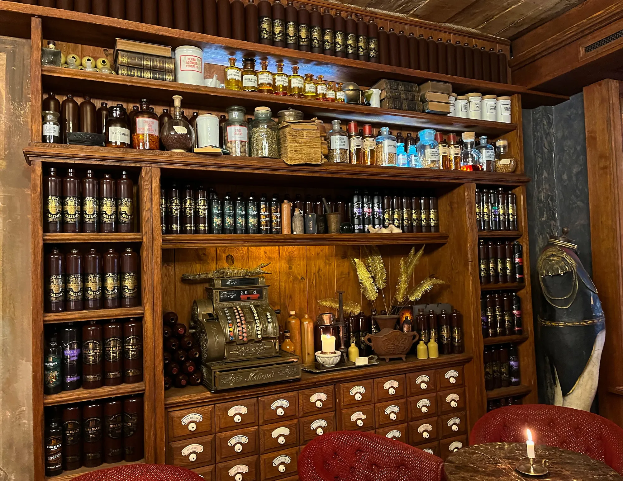 Wooden apothecary cabinet with black balsam bottles and tinctures