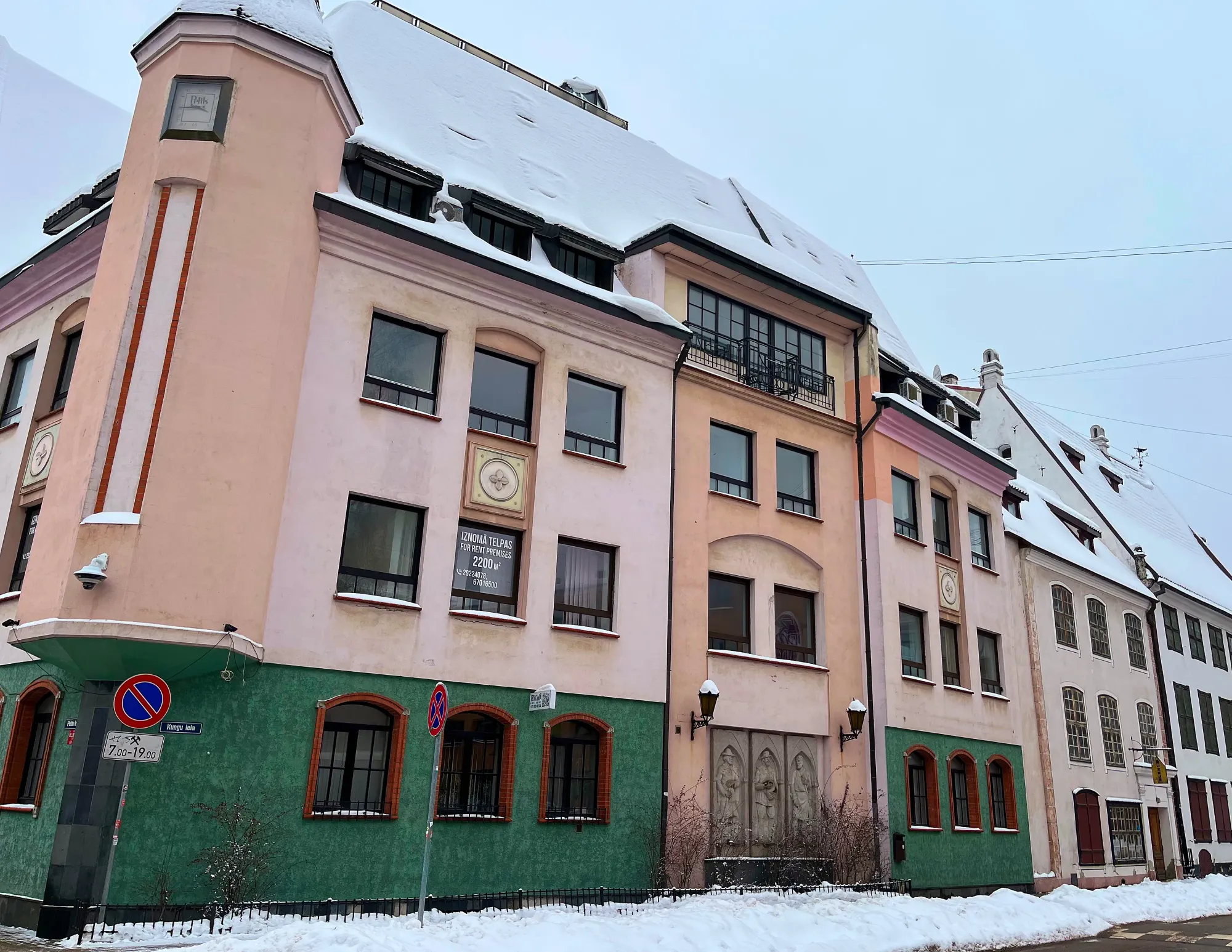 Pink and green buildings on a snow covered street