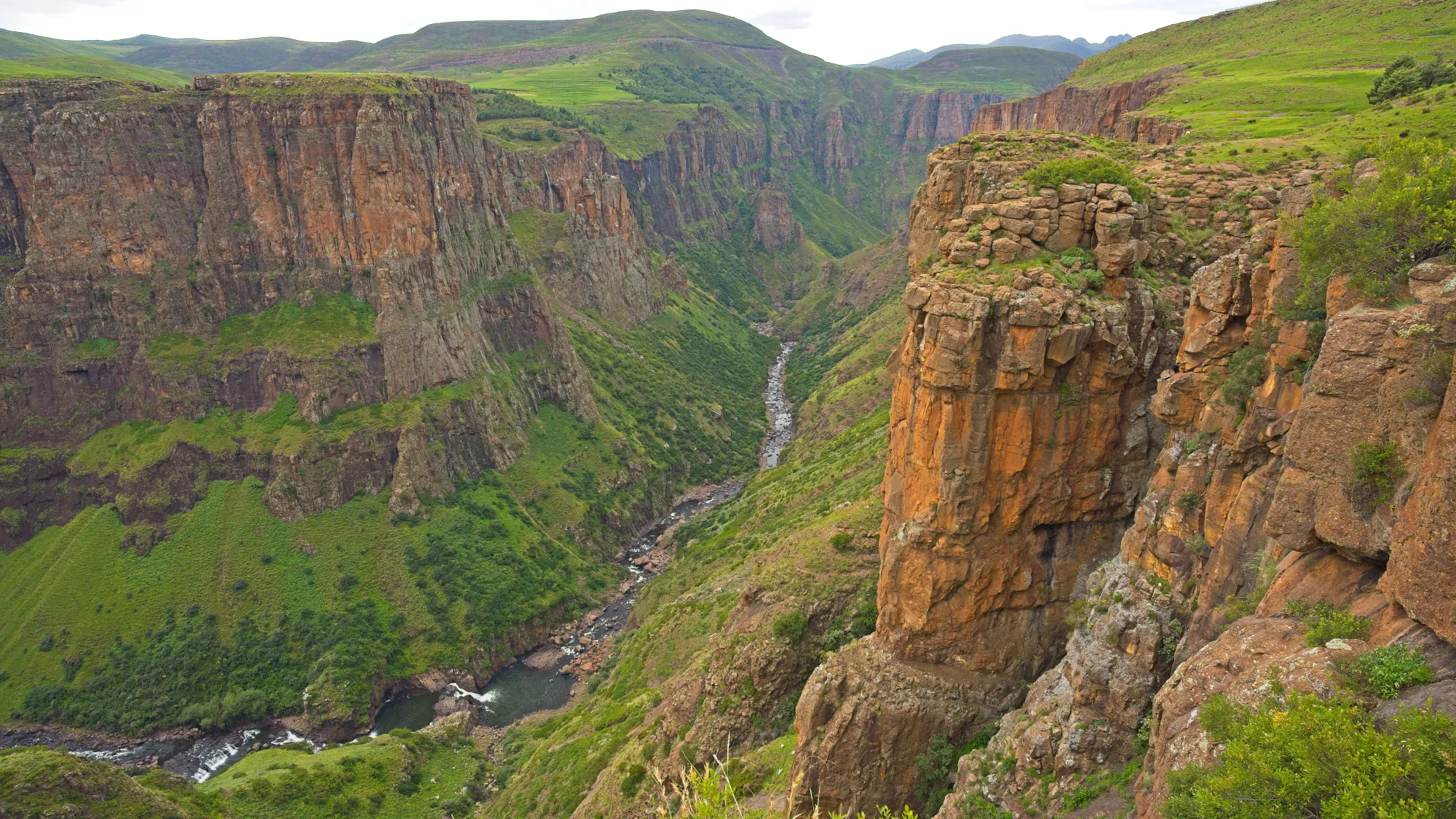 Valley with green grasses and a river running through it