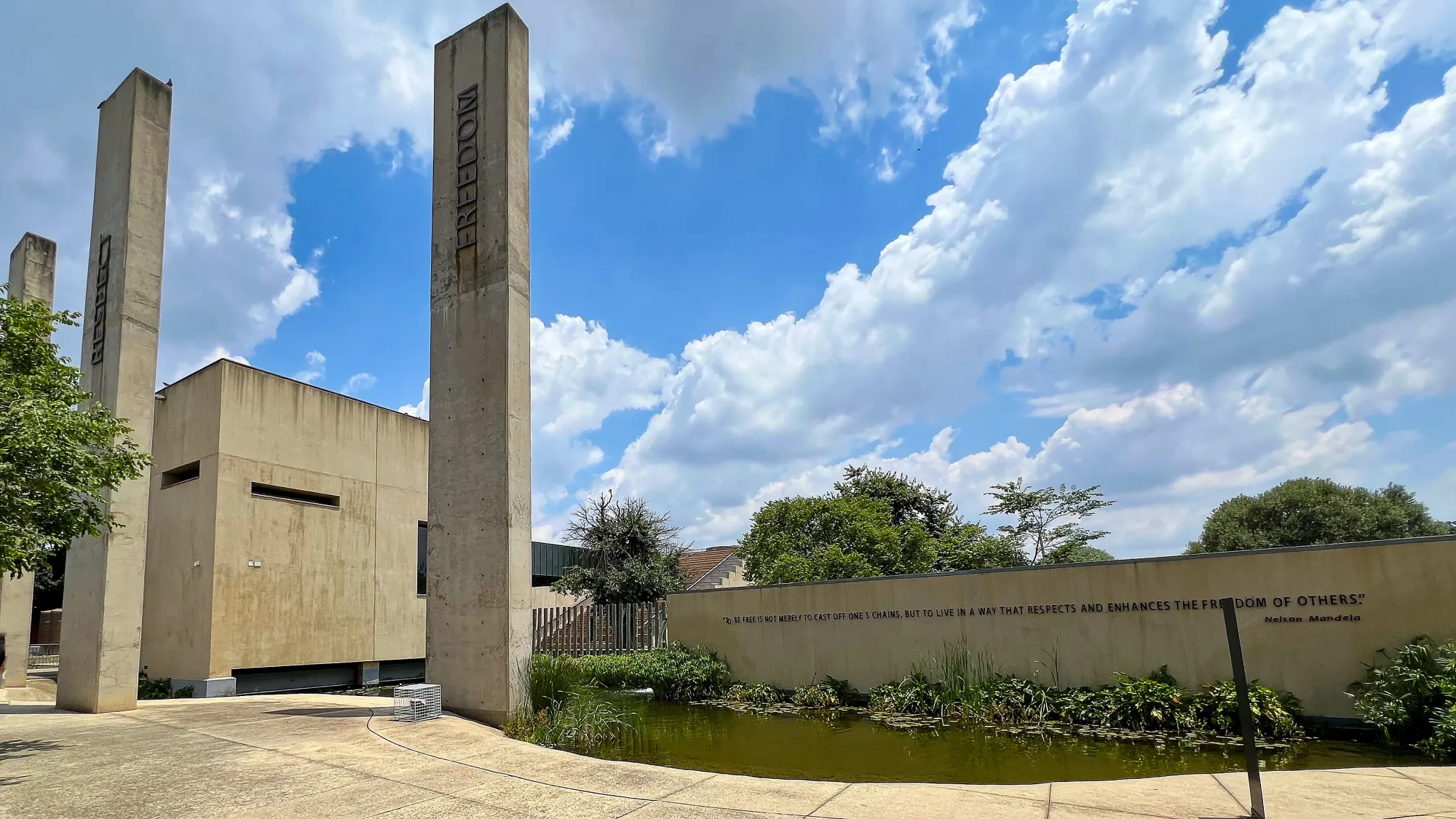 Concrete facade to the museum with pillars stating "Freedom" and "Respect"