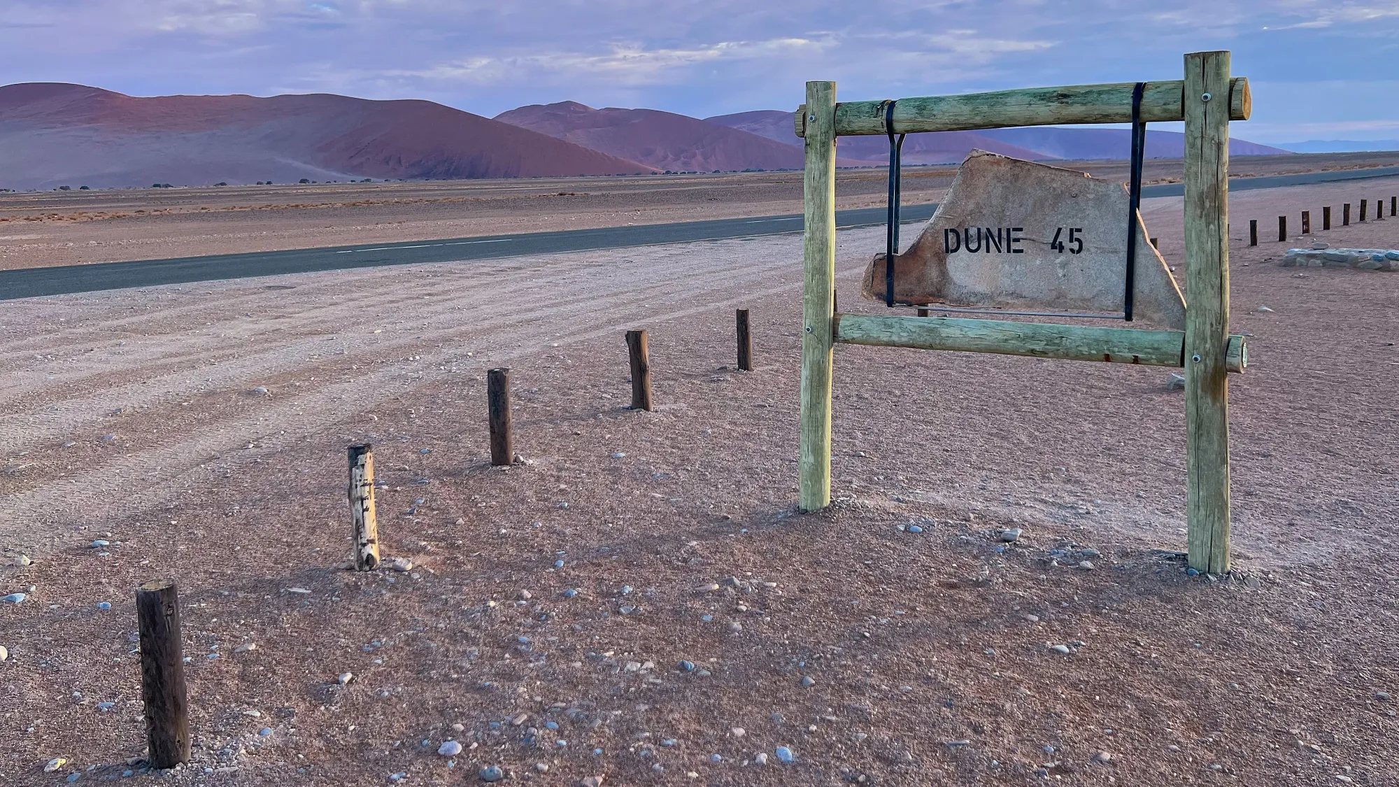 Wooden sign on lilac shaded sand