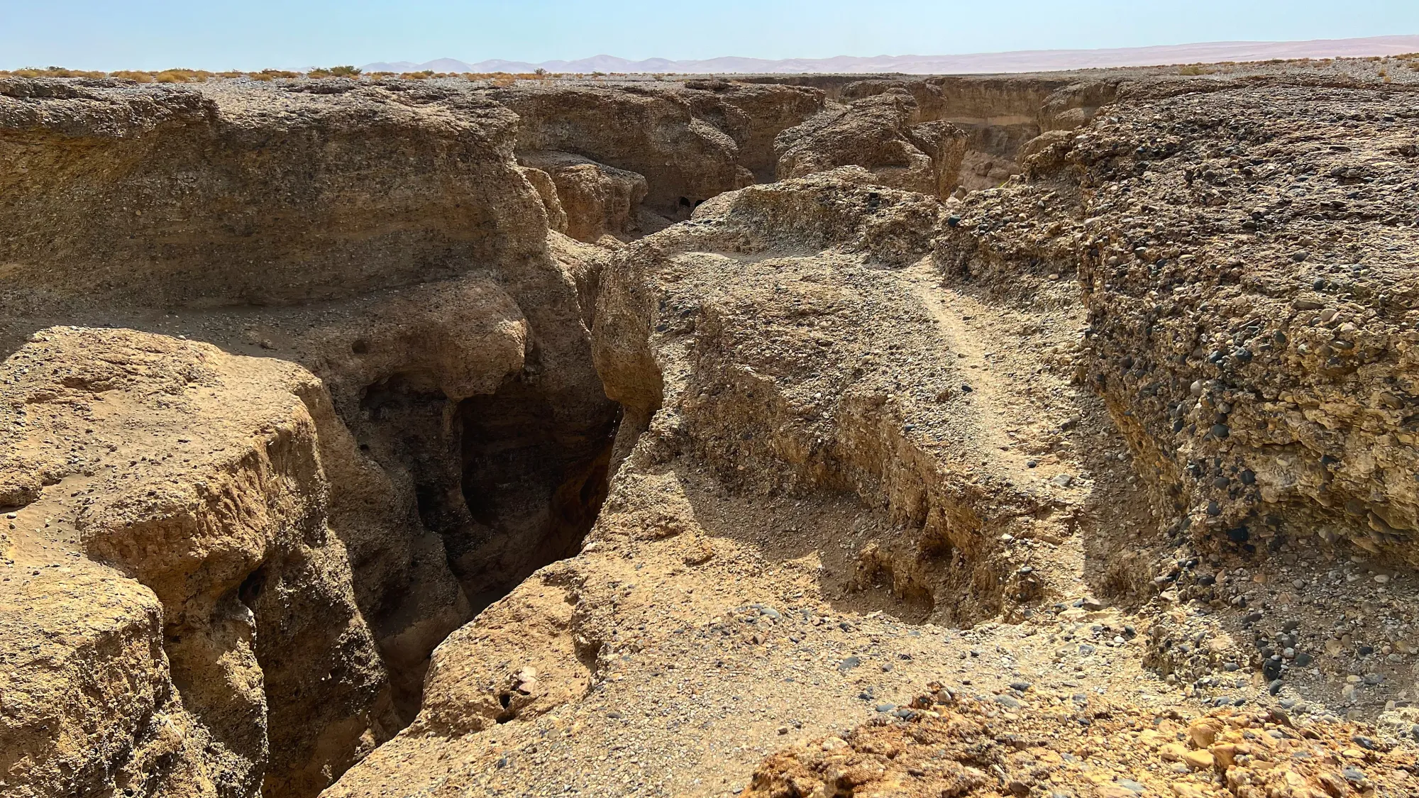 Rocky crevasse dropping out of the otherwise flat land