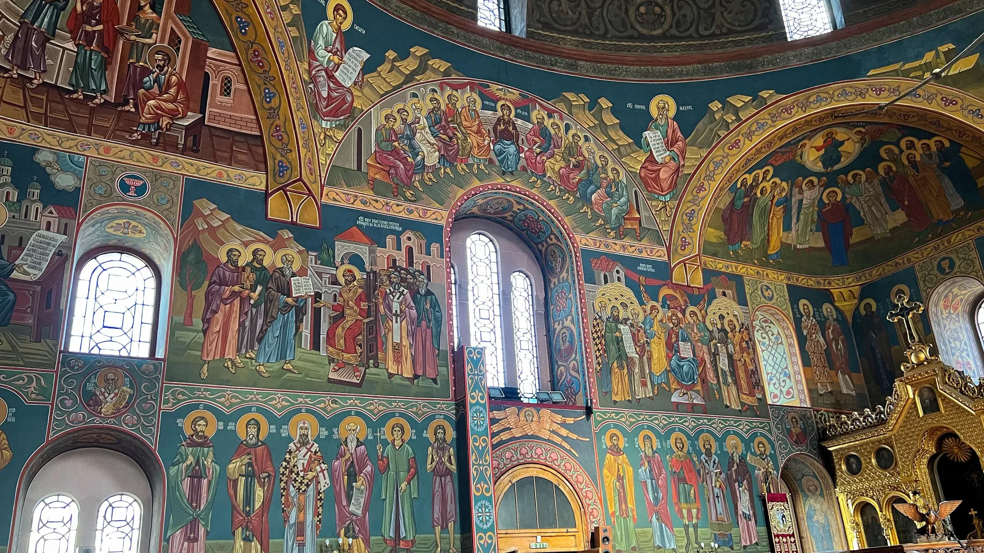 Rows of paintings on the church walls in vibrant colors and leaving no empty space