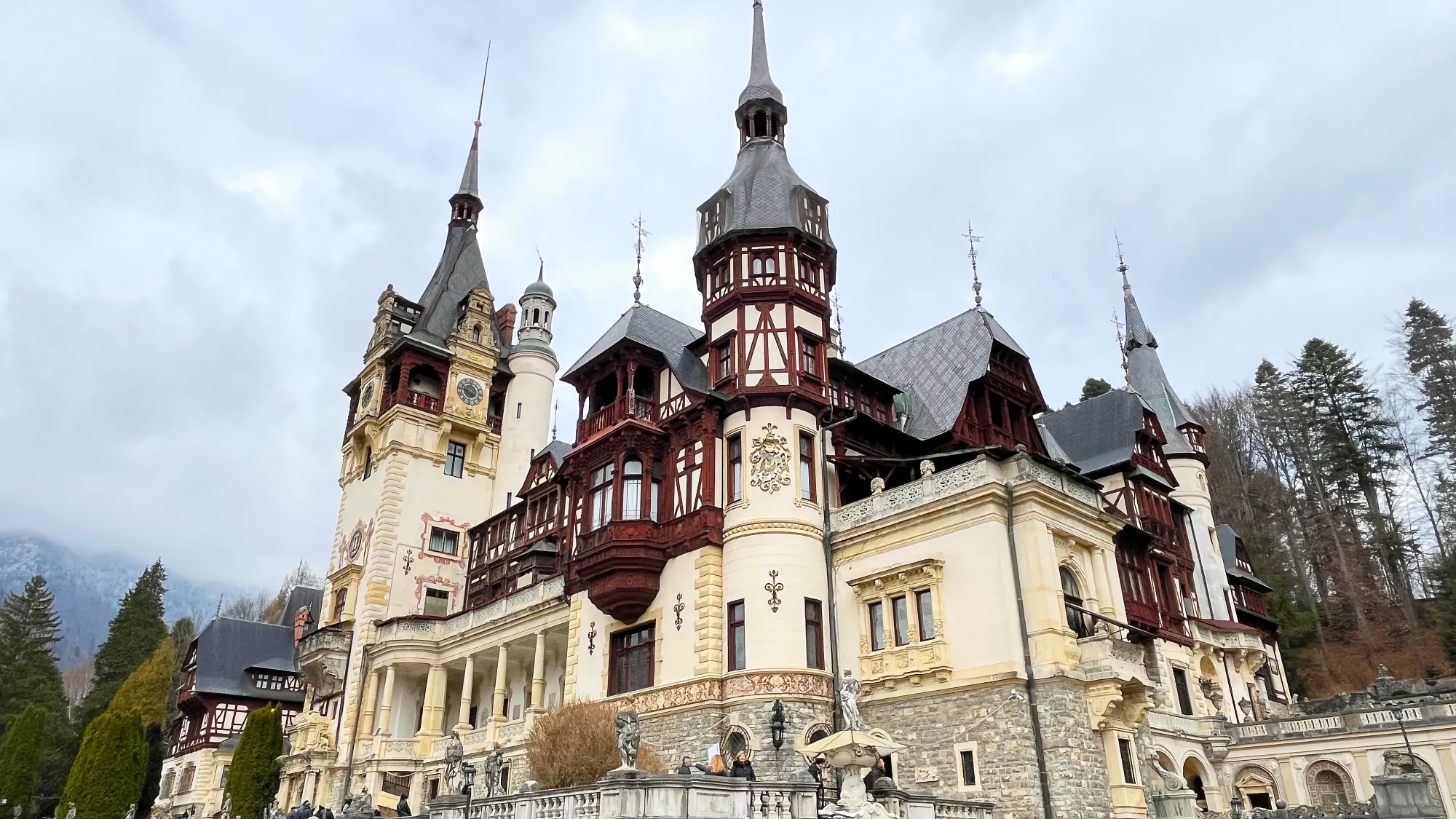 Stone, cream, and dark red-stained wooden castle with multiple turrets