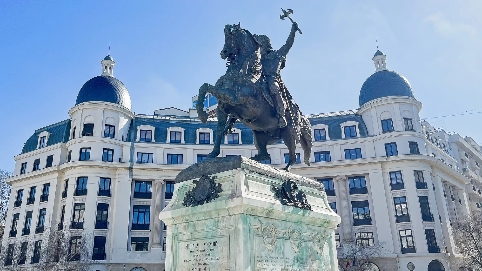 Statue of Man riding a horse atop a marble pedastal