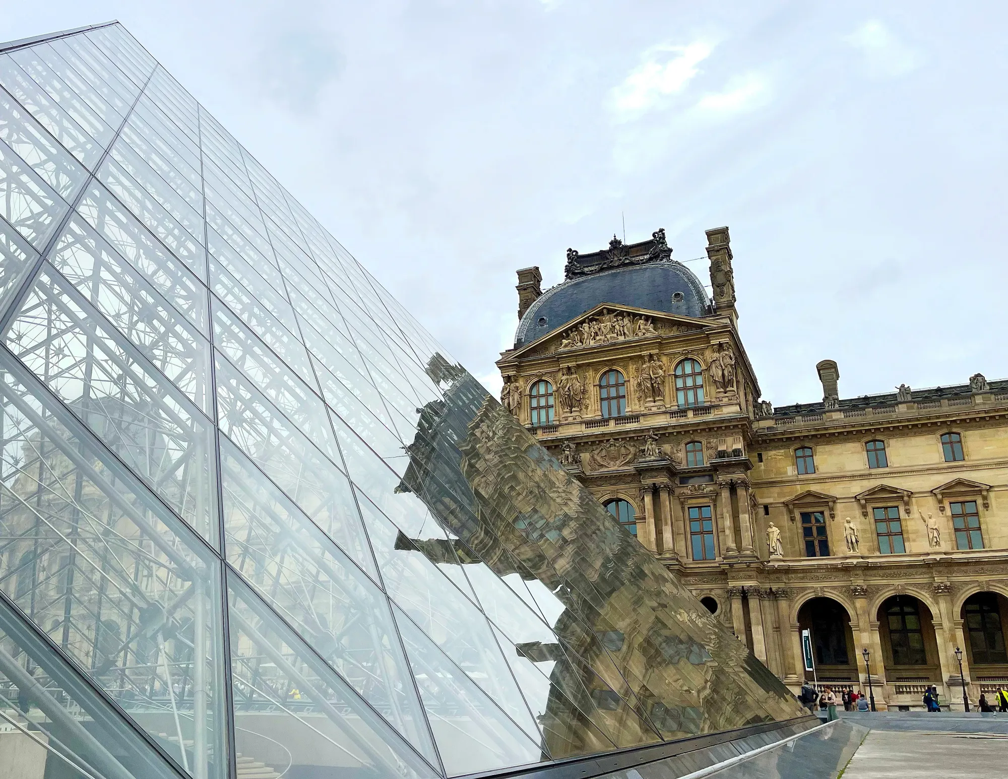 Reflection of the stone museum in the glass pyramid