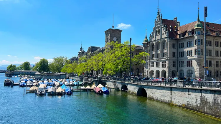 Blue water with covered boats and a stone walkway