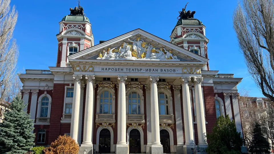 Two-storied columned building with Greek-style statues carved above the entrance